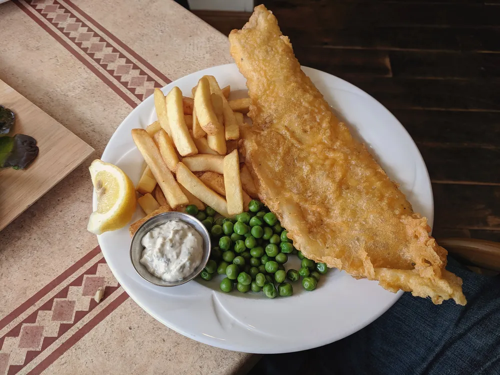Battered fish, chips, peas and tartare sauce (stock photo)